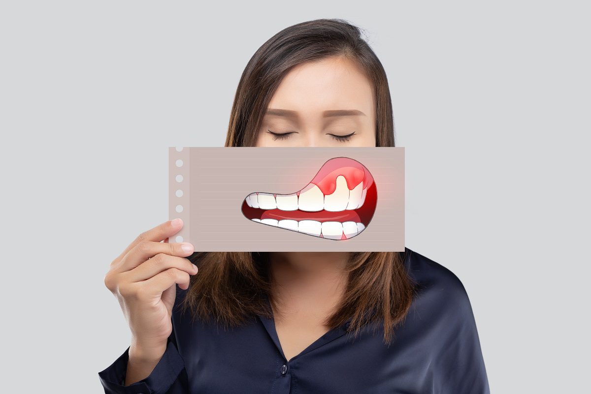 asian-woman-dark-blue-shirt-holding-paper-with-periodontal-gingivitis-cartoon-picture-his-mouth-against-gray-background-1.jpg